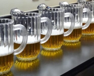 Rad med ölglas fyllda med gyllene öl och skum för provning